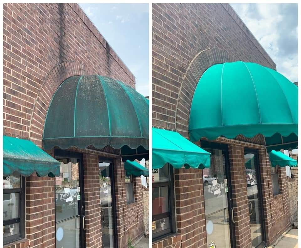 A professional carefully cleaning a commercial awning.