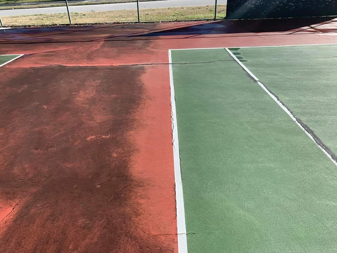 Tennis court cleaning in progress, low pressure soft wash application across an acrylic court surface in Middle Tennessee